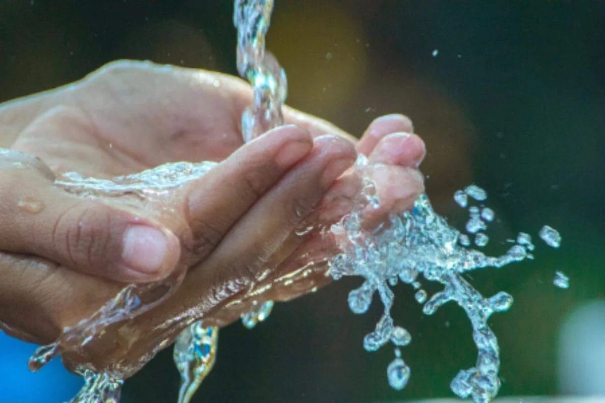 Manos recibiendo agua de un grifo